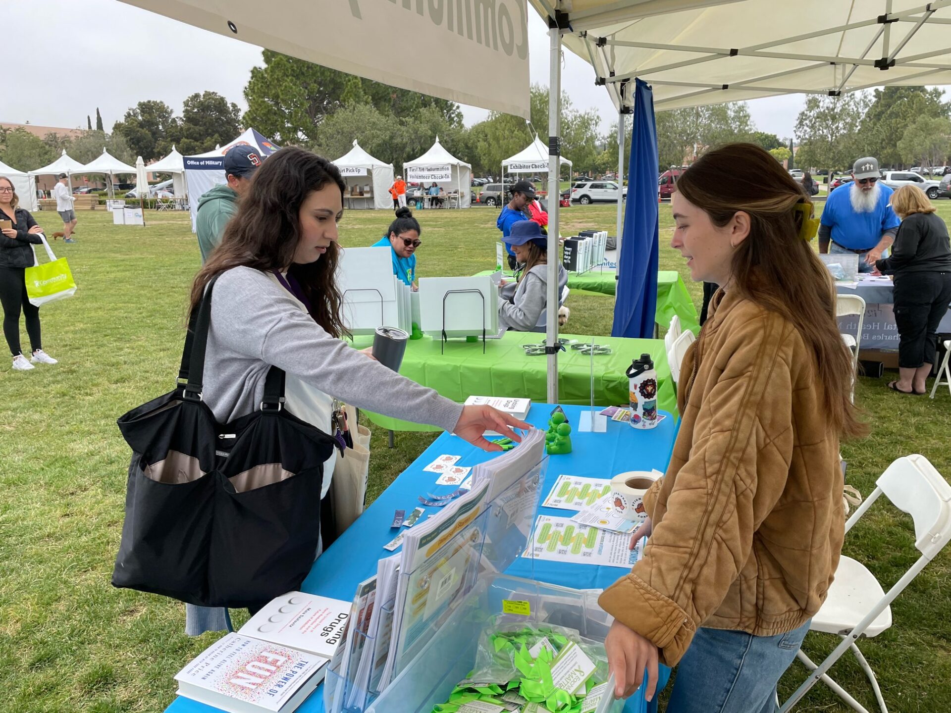 Take A Moment for your Mental Health at NAMIWalks and Wellness Expo Saturday | News Two people speak at the table at NAMIWalks San Diego