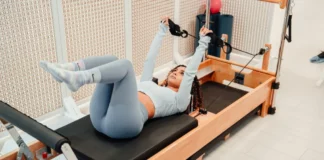 Pilates Equipment Poised to Become Next Home Gym Addition a woman working out on a Pilates reformer
