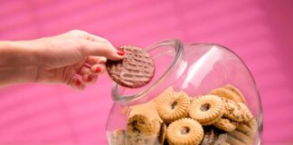 The surprising truth about the health benefits of snacking dieting woman sneaking a biscuit treat from the cookie jar