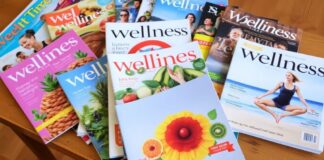 12 Top Wellness Publications – DMNews Collection of wellness magazines on a wooden table.