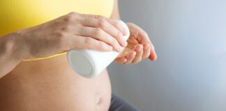 Cognitive gains from multivitamins depend on pregnancy diet Woman with pregnant belly hold medicine jar in hands
