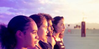 How Trump’s “Big, Beautiful Bill” Hurts Youth Mental Health – Non Profit News Four young people stand in a parking lot, looking at the sunset. There are mountains and palm trees in the distance.