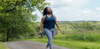 A walking coach says this exercise trend can help you hit 10,000 steps a day—here’s how woman in sports kit walking outside