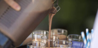 Protein is the latest and greatest food trend. But how much do we need? Someone adds Quest Nutrition protein powder to a shake. (Christopher Polk/Getty Images for Quest)