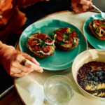 Oura Data Reveals Global Food Trends By Location, Age, and Gender Person wearing Oura Ring eating an open-faced bagel