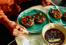 Oura Data Reveals Global Food Trends By Location, Age, and Gender Person wearing Oura Ring eating an open-faced bagel