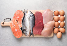Boy Kibble Be Gone: April Davis Talks Latest TikTok Diet Trends for Reporting Texas | Elson S. Floyd College of Medicine News A wooden cutting board displays a variety of protein-rich foods, including salmon fillets, two whole fish, raw red meat, and raw chicken breasts and a dozen brown eggs.